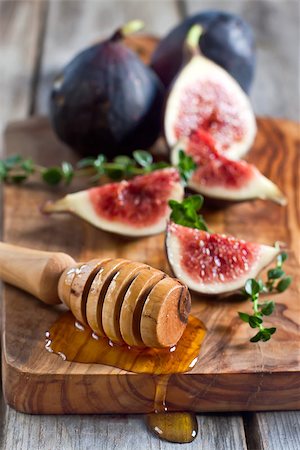 Ripe purple figs, thyme and homey on olive board. Selective focus. Stock Photo - Budget Royalty-Free & Subscription, Code: 400-07795840