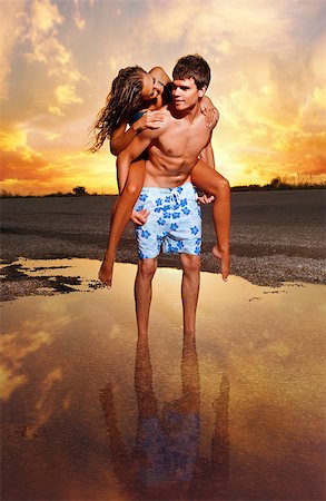 simsearch:400-06360128,k - young couple kissing at the beach with the sun setting behind them Stock Photo - Budget Royalty-Free & Subscription, Code: 400-07796844