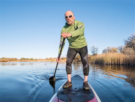 simsearch:400-07795226,k - senior paddler in life jacket enjoying stand up paddling on lake, fall scenery in Fort Collins, Colorado Foto de stock - Royalty-Free Super Valor e Assinatura, Número: 400-07797299