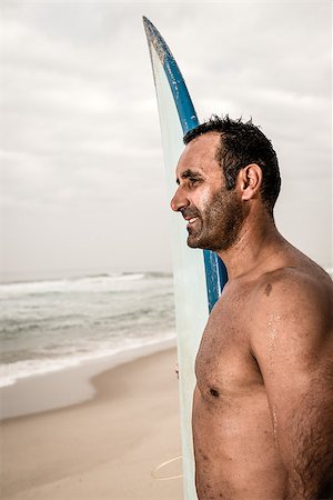 simsearch:400-07952893,k - Surfer wathing the waves on the beach with his surfboard. Stock Photo - Budget Royalty-Free & Subscription, Code: 400-07792171