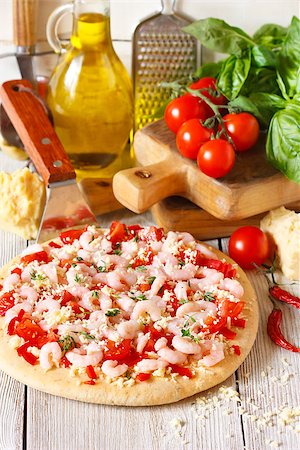 simsearch:400-07314797,k - Hot shrimp pizza on a pizza maker shovel and fresh food ingredients. Photographie de stock - Aubaine LD & Abonnement, Code: 400-07792936