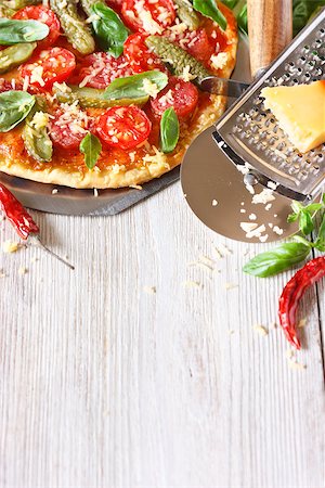 simsearch:400-04539943,k - Delicious salami pizza, pizza knife and cheese grater on a white wooden background with copy space for recipe Stockbilder - Microstock & Abonnement, Bildnummer: 400-07792986