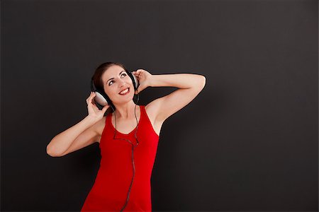 Happy woman over a black background listen music with headphones Stock Photo - Budget Royalty-Free & Subscription, Code: 400-07793556