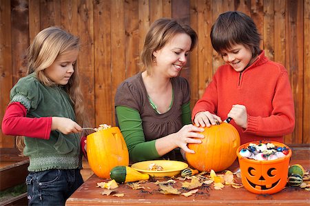 simsearch:400-07793717,k - Woman helping kids to carve their pumpkin Halloween jack-o-lantern Photographie de stock - Aubaine LD & Abonnement, Code: 400-07793711