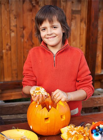 simsearch:400-07793720,k - Closeup of boy carving a pumpkin Halloween jack-o-lantern - removing the seeds Photographie de stock - Aubaine LD & Abonnement, Code: 400-07793712