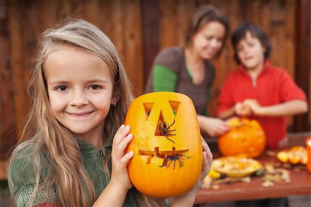 simsearch:400-07793717,k - Little girl showing her freshly carved Halloween jack-o-lantern Photographie de stock - Aubaine LD & Abonnement, Code: 400-07793721