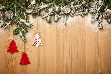 Christmas background with fresh firtree, decorative handmade trees and cones on wood with bright snow Stock Photo - Budget Royalty-Free & Subscription, Code: 400-07817731
