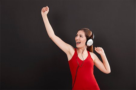 Happy woman over a black background listen music with headphones Stock Photo - Budget Royalty-Free & Subscription, Code: 400-07817878