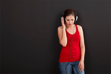 Happy woman over a black background listen music with headphones Stock Photo - Budget Royalty-Free & Subscription, Code: 400-07817880