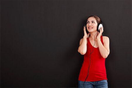 Happy woman over a black background listen music with headphones Stock Photo - Budget Royalty-Free & Subscription, Code: 400-07817882