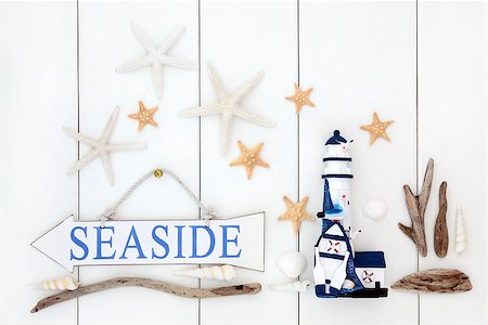 simsearch:400-07818974,k - Seaside sign, starfish shells, driftwood and decorative lighthouse over wooden white background. Stock Photo - Budget Royalty-Free & Subscription, Code: 400-07818763