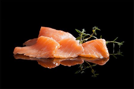 simsearch:400-08070549,k - Smoked salmon pieces isolated on black background with fresh herbs. Culinary seafood. Stockbilder - Microstock & Abonnement, Bildnummer: 400-07819519