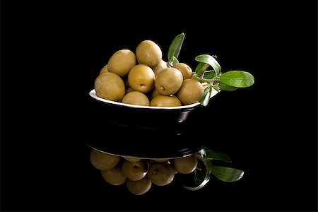 Delicious green olives in black bowl isolated on black background. Luxurious culinary starter. Stock Photo - Budget Royalty-Free & Subscription, Code: 400-07819524
