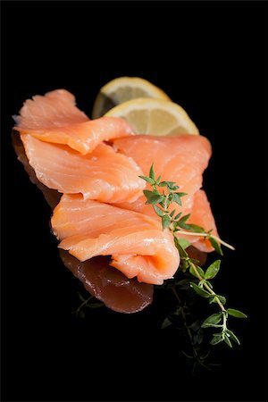 simsearch:400-08070549,k - Smoked salmon with fresh herbs and lemon isolated on black background. Culinary seafood. Stockbilder - Microstock & Abonnement, Bildnummer: 400-07819520