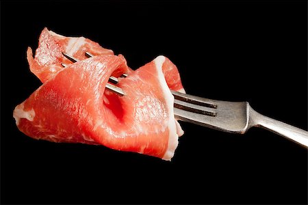 simsearch:400-08071181,k - Delicious culinary prosciutto ham on silver fork isolated on black background. Culinary appetizer eating. Foto de stock - Super Valor sin royalties y Suscripción, Código: 400-07819536