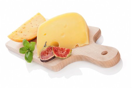 emmentaler cheese - Swiss cheese and gouda piece on wooden cutting board isolated on white background decorated with fig and fresh basil. Luxurious cheese still life. Stock Photo - Budget Royalty-Free & Subscription, Code: 400-07819532