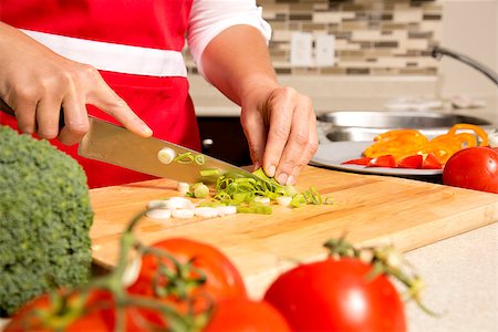 caucasian woman is cutting raw vegetables  on the kitchen table Stock Photo - Budget Royalty-Free & Subscription, Code: 400-07824247