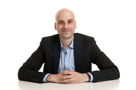 simsearch:400-07820348,k - portrait of a cheerful businessman sitting at a table, isolated over white background Photographie de stock - Aubaine LD & Abonnement, Code: 400-07824651