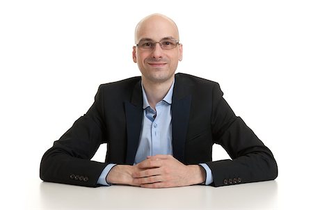 simsearch:400-07820348,k - portrait of a cheerful businessman sitting at a table, isolated over white background Photographie de stock - Aubaine LD & Abonnement, Code: 400-07824653