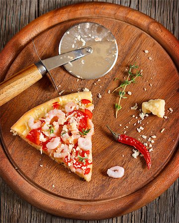 simsearch:400-07314797,k - Piece of hot shrimp pizza and pizza knife on a wooden cooking board. Photographie de stock - Aubaine LD & Abonnement, Code: 400-07824842