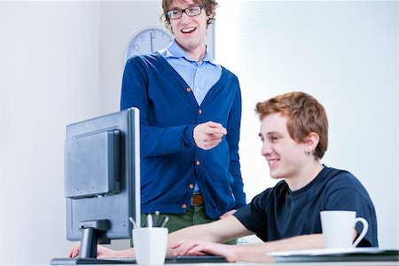 simsearch:400-07681479,k - a couple of young office workers smiling at a screen Stock Photo - Budget Royalty-Free & Subscription, Code: 400-07825717