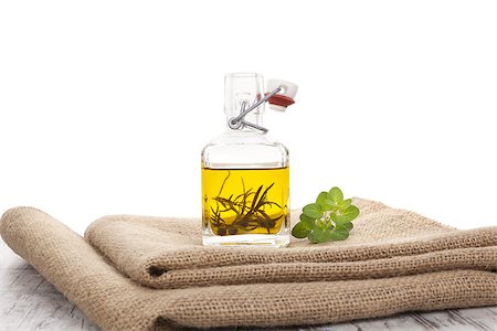 Culinary extra virgin olive oil still life. Olive oil with herbs in glass bottle on burlap cloth on wooden background. Stockbilder - Microstock & Abonnement, Bildnummer: 400-07825800