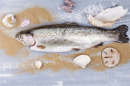 Culinary seafood eating. Fresh trout on blue wooden background with sand, sea salt and seashell. Stock Photo - Budget Royalty-Free & Subscription, Code: 400-07825857
