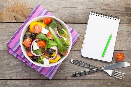 simsearch:400-06485512,k - Fresh healthy salad and notepad for copy space and silverware on wooden table. View from above Stock Photo - Budget Royalty-Free & Subscription, Code: 400-07829781