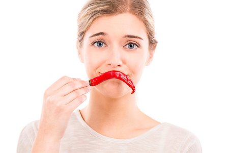 simsearch:400-04575822,k - Beautiful girl making a sad face with a red chilli pepper in front of the mouth, isolated over a white background Photographie de stock - Aubaine LD & Abonnement, Code: 400-07820155