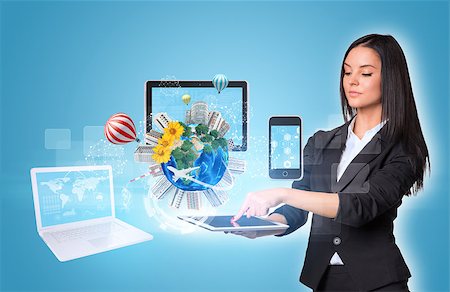 simsearch:400-07821752,k - Beautiful businesswomen in suit using digital tablet. Earth with buildings and laptop, tablet and smartphone. Element of this image furnished by NASA Foto de stock - Royalty-Free Super Valor e Assinatura, Número: 400-07821695