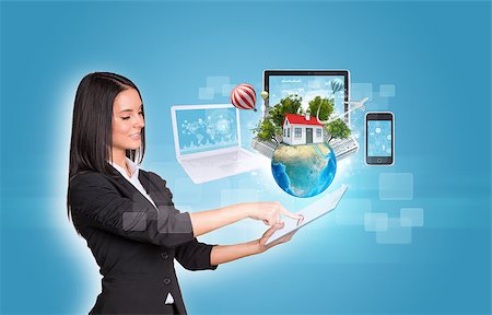 simsearch:400-07821752,k - Beautiful businesswomen in suit using digital tablet. Earth with buildings and laptop, tablet and smartphone. Element of this image furnished by NASA Foto de stock - Royalty-Free Super Valor e Assinatura, Número: 400-07821693