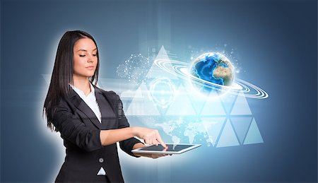 simsearch:400-07895693,k - Beautiful businesswomen in suit using digital tablet. Earth with triangles and network. Element of this image furnished by NASA Stock Photo - Budget Royalty-Free & Subscription, Code: 400-07821714