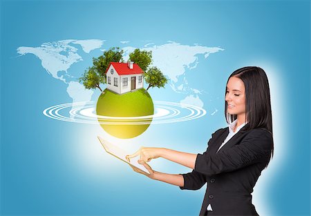Beautiful businesswomen in suit using digital tablet. Earth with house and trees. World map as backdrop Stock Photo - Budget Royalty-Free & Subscription, Code: 400-07821827