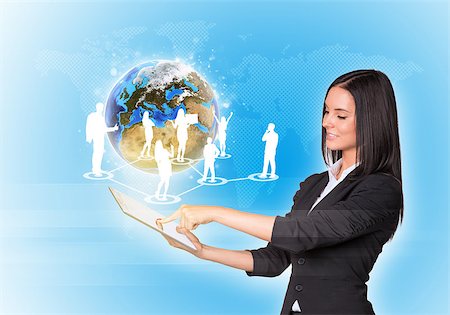 simsearch:400-07821752,k - Beautiful businesswomen in suit using digital tablet. Earth with silhouettes of business people. Element of this image furnished by NASA Foto de stock - Royalty-Free Super Valor e Assinatura, Número: 400-07821871