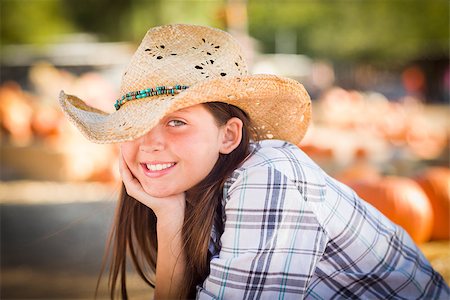 simsearch:400-07179959,k - Pretty Preteen Girl Wearing Cowboy Hat Portrait at the Pumpkin Patch in a Rustic Setting. Stockbilder - Microstock & Abonnement, Bildnummer: 400-07821891