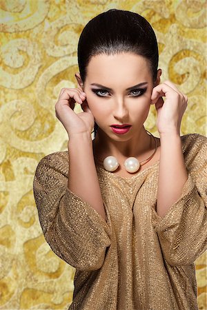 simsearch:400-07822212,k - charming young female with stylish make-up wearing elegant shiny gold dress and pretty big necklace. In fashion pose Fotografie stock - Microstock e Abbonamento, Codice: 400-07822213