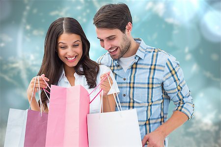 Happy couple with shopping bags against blurred christmas background Stock Photo - Budget Royalty-Free & Subscription, Code: 400-07834030