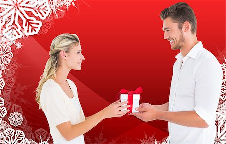 simsearch:400-07834588,k - Young couple with gift against christmas themed snow flake frame Fotografie stock - Microstock e Abbonamento, Codice: 400-07834086