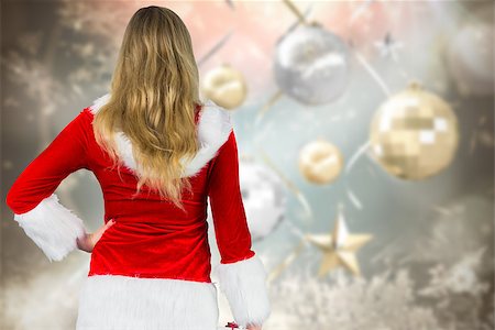 simsearch:400-07834588,k - Pretty girl in santa outfit holding gift against blurred christmas background Fotografie stock - Microstock e Abbonamento, Codice: 400-07834172