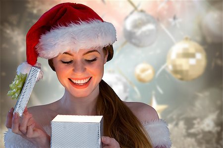 simsearch:400-07834588,k - Sexy girl in santa costume opening a gift against blurred christmas background Fotografie stock - Microstock e Abbonamento, Codice: 400-07834182