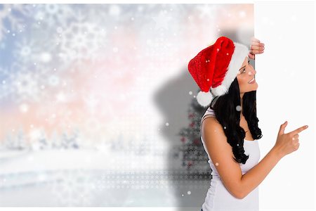 simsearch:400-07755560,k - Woman pointing to large sign against blurry christmas scene Stock Photo - Budget Royalty-Free & Subscription, Code: 400-07834543