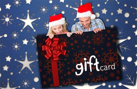 simsearch:400-07834588,k - Young festive couple against gift card with festive bow Fotografie stock - Microstock e Abbonamento, Codice: 400-07834588