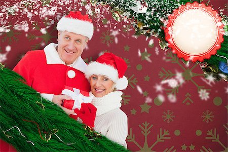 simsearch:400-07834588,k - Festive mature couple holding gift against snowflake wallpaper pattern Fotografie stock - Microstock e Abbonamento, Codice: 400-07834605