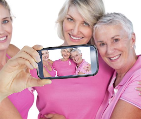 Composite image of hand holding smartphone showing photograph of breast cancer activists Foto de stock - Super Valor sin royalties y Suscripción, Código: 400-07834625