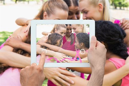 Composite image of hand holding device showing photograph of breast cancer activists Foto de stock - Super Valor sin royalties y Suscripción, Código: 400-07834696