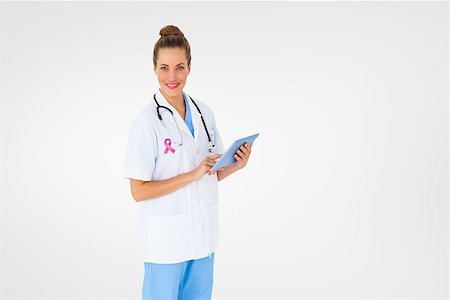 Pretty nurse using tablet pc against white background with vignette Stock Photo - Budget Royalty-Free & Subscription, Code: 400-07834922
