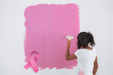 simsearch:400-07834992,k - Young woman painting her wall in pink against pink breast cancer awareness ribbon Fotografie stock - Microstock e Abbonamento, Codice: 400-07834976