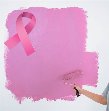 simsearch:400-07834992,k - Woman painting her wall pink against pink breast cancer awareness ribbon Fotografie stock - Microstock e Abbonamento, Codice: 400-07834979