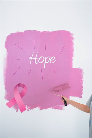 simsearch:400-07834992,k - Woman painting her wall pink against pink breast cancer awareness ribbon Fotografie stock - Microstock e Abbonamento, Codice: 400-07834990