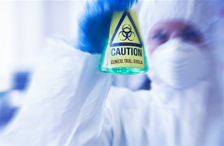 simsearch:400-07835228,k - Scientist in protective suit holding beaker with caution sticker Stockbilder - Microstock & Abonnement, Bildnummer: 400-07835235